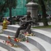 En chantant le monument `a Vysotsky portent des fleurs, cognac et cigarettes