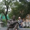 En chantant le monument `a Vysotsky portent des fleurs, cognac et cigarettes